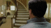 a man standing in front of a set of stairs in a house .