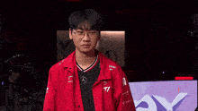 a man wearing glasses and a red shirt with mercedes on it