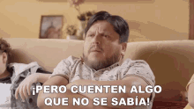 a man sits on a couch with his arms crossed and says pero cuenten algo que no se sabia !