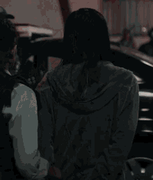 a woman is standing in front of a car that has the number 18 on it