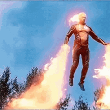 a man in a superhero costume is flying through the air with flames coming out of his legs