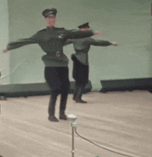 a couple of men in military uniforms are dancing on a stage .