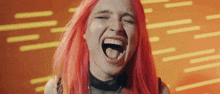 a woman with red hair is screaming with her mouth open and her tongue sticking out .