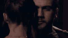 a man and a woman are looking at each other in the dark
