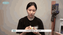 a woman is holding something in front of a vacuum cleaner and a sign that says mina tv
