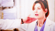 a woman in a lab coat with a ponytail looks surprised