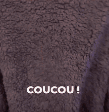 a woman in a red and black gaming chair says coucou !