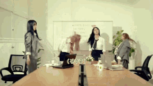 a group of women are standing around a conference table with a white board behind them that says wifi