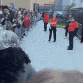 a woman in a red shirt stands in a crowd