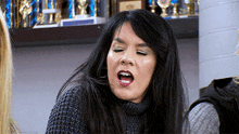 a woman in a sweater is making a funny face