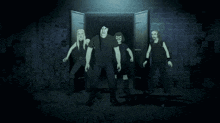 a group of men are standing in a dark room