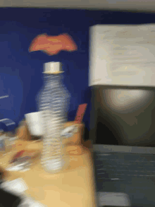 a bottle of water sits on a table in front of a computer