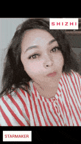 a woman wearing a red and white striped shirt with a starmaker sticker on the bottom