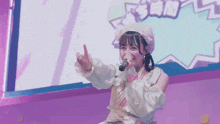 a girl singing into a microphone in front of a screen that says ' snm ' on it