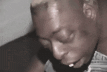 a close up of a man 's face with his mouth open and a cigarette in his mouth .