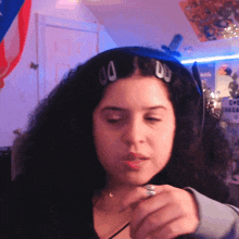 a woman with a ring on her finger is wearing hair clips that say 00 on them