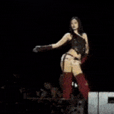 a woman is standing on top of a stage in front of a crowd .