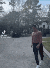 a man without a shirt is walking down a street with a tiktok hashtag