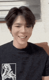 a young man wearing a black t-shirt with a floral design on it