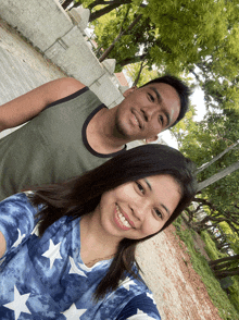 a man and a woman are posing for a picture and the woman is wearing a shirt with stars
