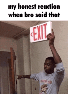 a man is holding an exit sign over his head and pointing .