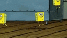 three spongebob squarepants cubes are dancing together on a wooden floor .