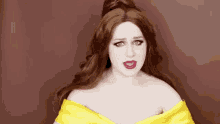 a woman is wearing a yellow dress and making a funny face .