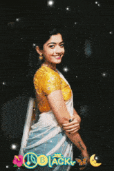 a woman in a white and blue saree is smiling in front of a black background