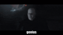 a blurry picture of a man in a dark room with the words `` genius '' written on the bottom .