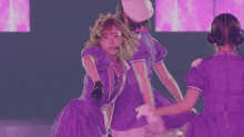 a woman in a purple dress with a microphone in her mouth