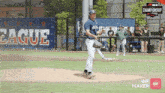 a baseball pitcher stands on the mound in front of a banner that says league