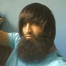 a man with long hair and a beard takes a selfie