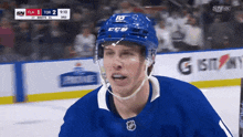 a hockey player wearing a blue ccm helmet stands on the ice