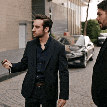 a man in a suit holds a key while standing next to another man