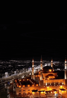 a mosque is lit up at night with a storm coming in the background