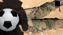 a soccer ball is on the ground next to a soldier