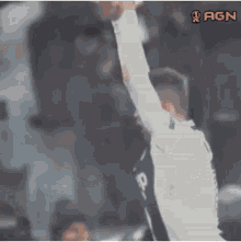 a blurry picture of a soccer player with the agn logo in the corner