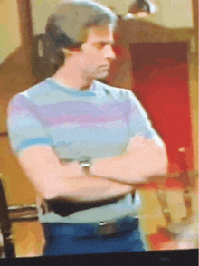 a man with his arms crossed is on a tcl television
