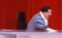 a blurry picture of a man sitting at a table .