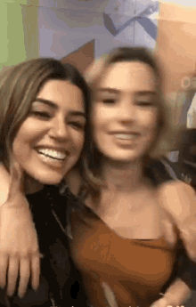 two women are posing for a picture and one of them is wearing a black top