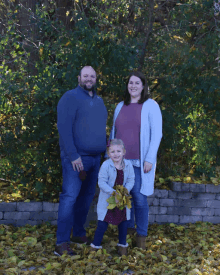 a family posing for a picture with leaves in the background