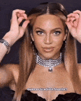 a woman wearing a choker necklace and earrings says quien es tu artista favorita