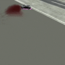 a black car is driving down a highway with a pink stripe on the side