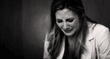 a black and white photo of a woman crying in a room .