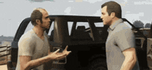 two men are standing next to each other in front of a car in a video game .