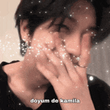 a close up of a person covering their mouth with their hand and the words doyum de kamila written on the bottom