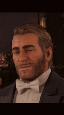 a man in a tuxedo and bow tie smiles at the camera