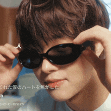 a close up of a person wearing sunglasses with the words c-c-c-crazy below