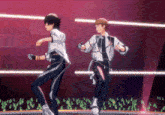 two anime characters are dancing on a stage in front of a crowd
