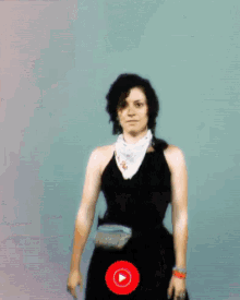 a woman in a black dress with a white scarf around her neck and a red play button
